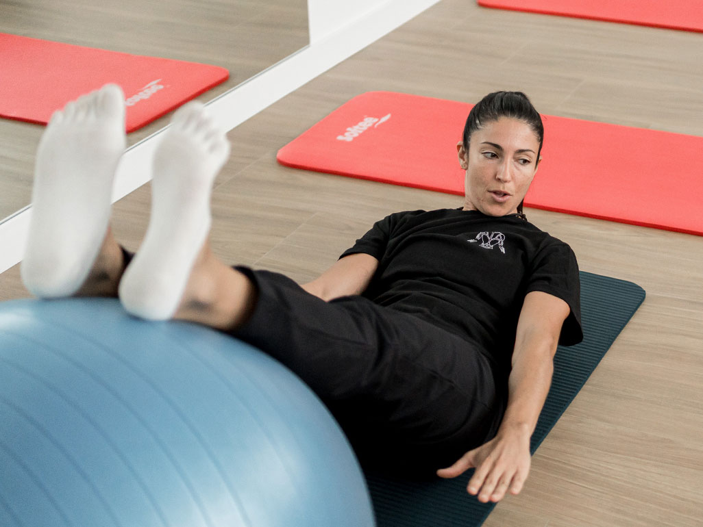 Muestra en la imagen a la profesora de Pilates dl centro Ernesto Jover impartiendo una clase con balones medicinales